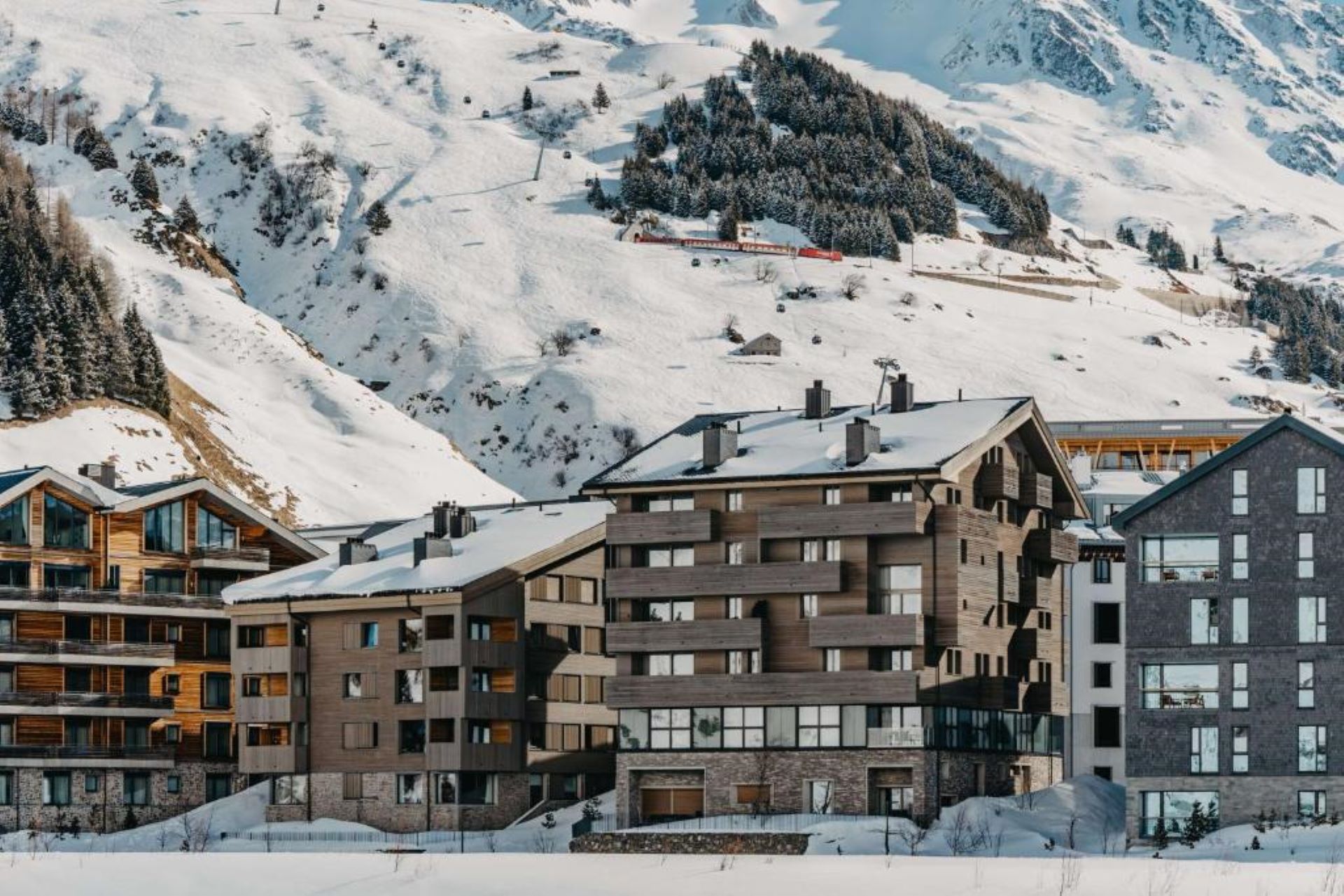 View of Andermatt Alpine Apartments with ski slopes behind