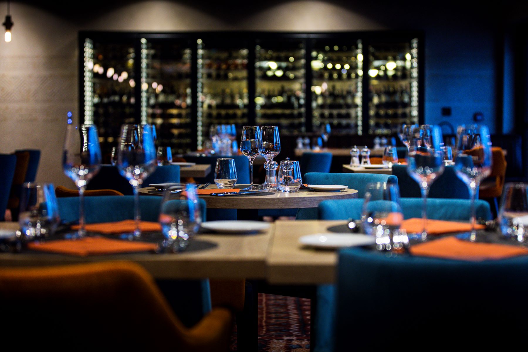 Daria-I-Nor Alpe d'Huez - Dining room with blue chairs and a large wine fridge