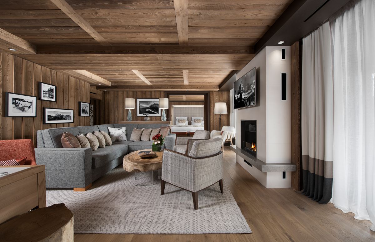 Hotel Fouquet's Courchevel - Large living room with l shaped sofa chairs coffee table tv and working fire
