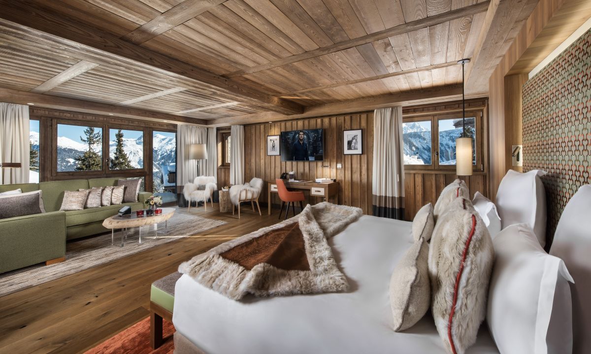 Hotel Fouquet's Courchevel - Junior suite with double bed living area with sofa writing desk TV and three windows with mountain views