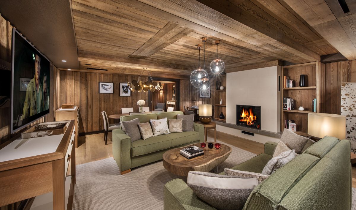 Hotel Fouquet's Courchevel - Living dining room with two sofas large tv coffee table side units and working fire