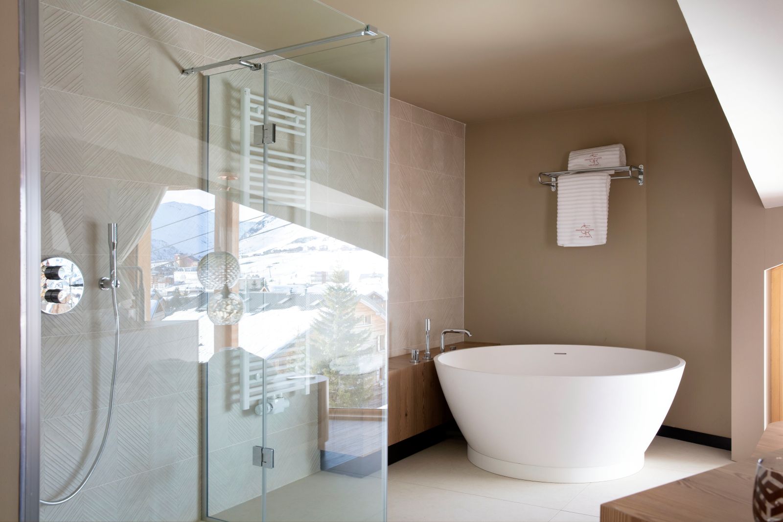 Grandes Rousses Hotel & Spa Alpe d'Huez - Large bathroom with round freestanding bath and walk in shower