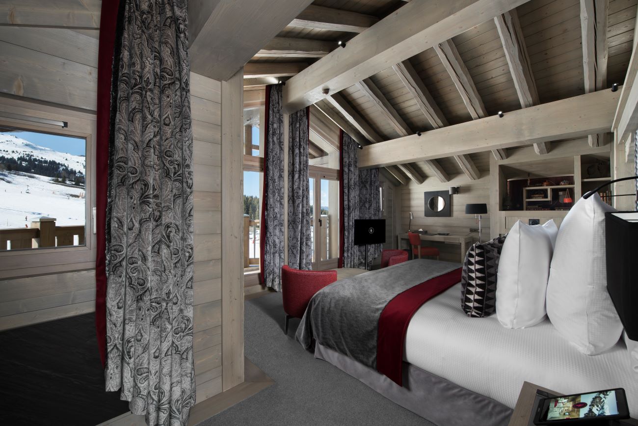 Hotel Le K2 Altitude Courchevel - large airy bedroom with seating area tv writig desk storage and access to a balcony