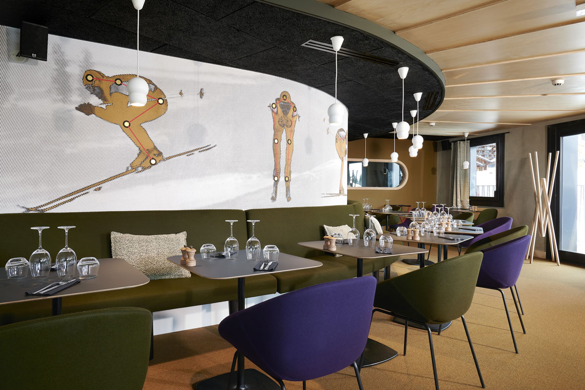 Hotel Mil8 Avoriaz - Hotel restaurant seating area with skiing art work
