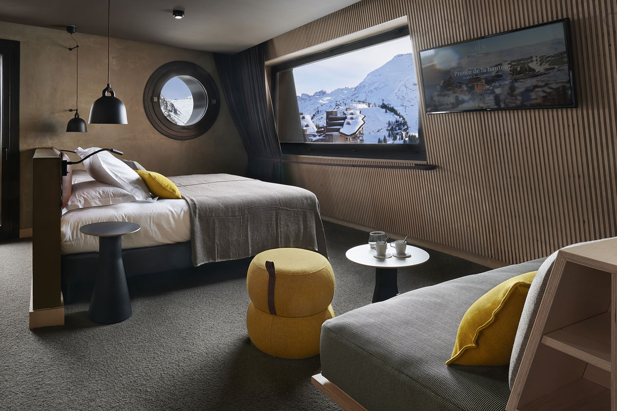 Hotel Mil8 Avoriaz - Hotel large bedroom with seating area portal window and picture window with views of mountains