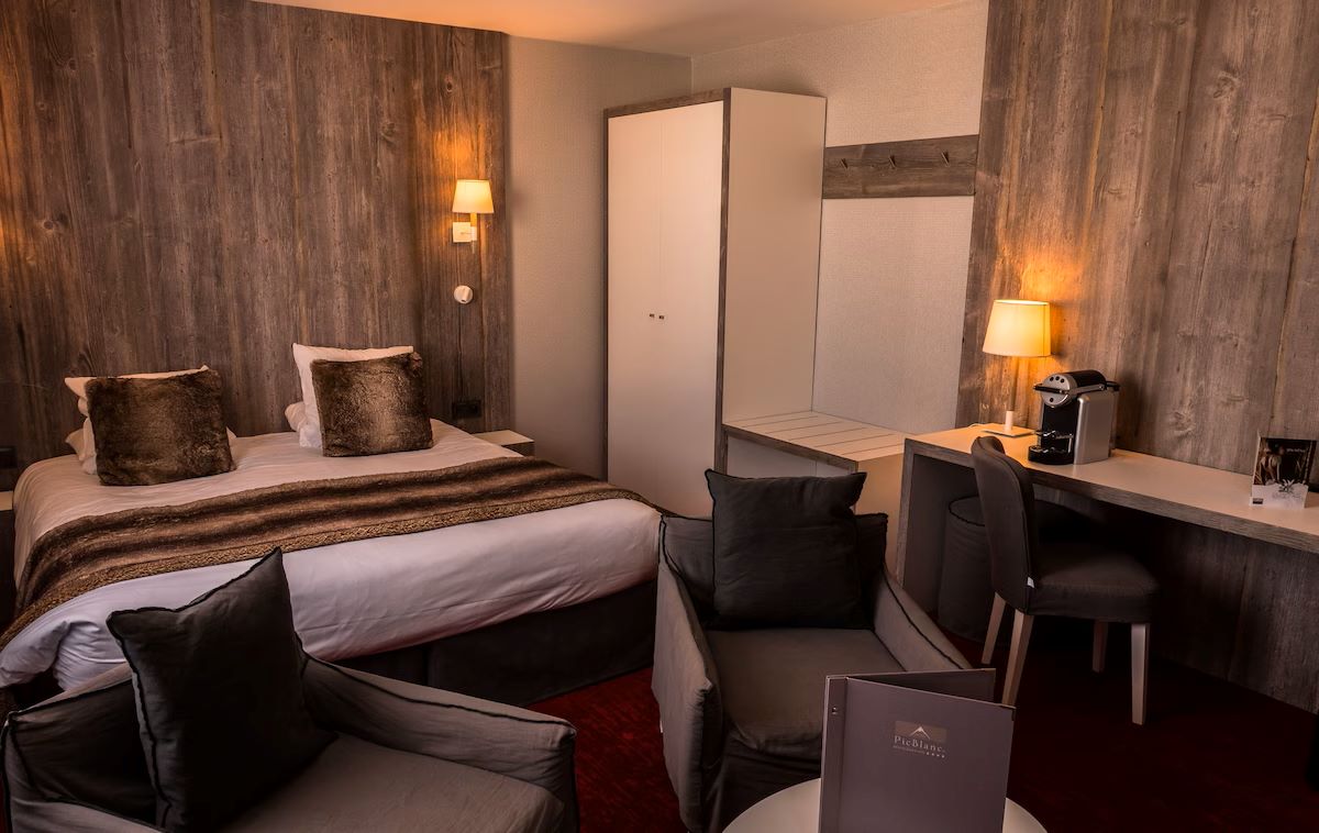 Hotel Le Pic Blanc Alpe d'Huez - Hotel cosy bedroom with small seating rea wardrobe and tea maker