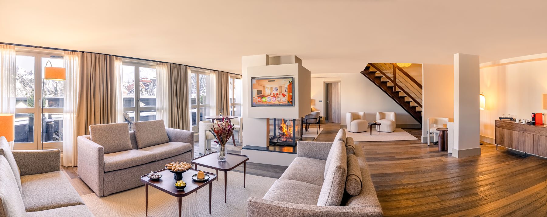 Les Suites de la Potinière Courchevel - Bright airy spacious open planned living room dining room with three sofas separate seating areas a fire and private balcony
