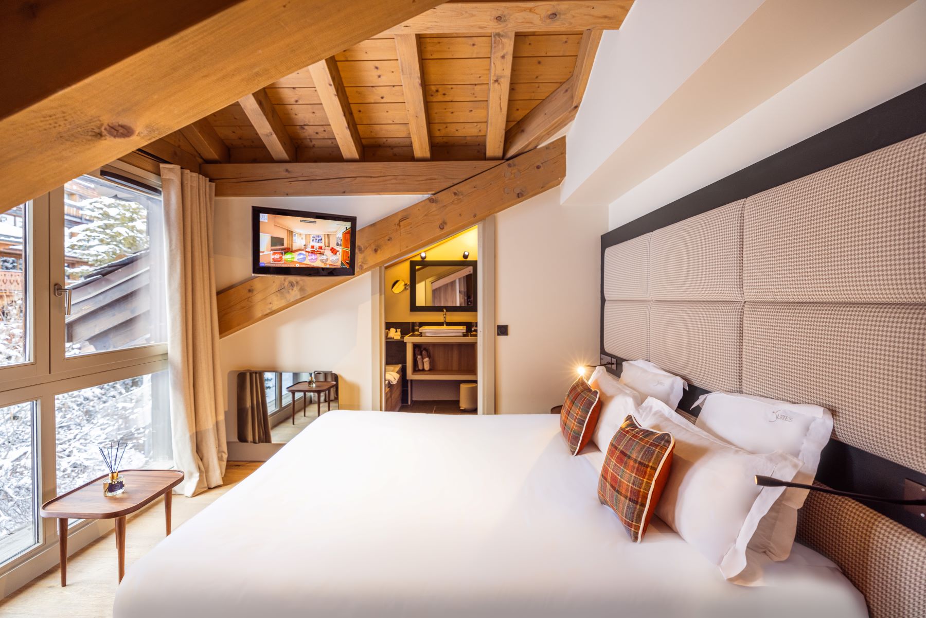 Les Suites de la Potinière Courchevel - cosy loft style double bedroom with picturesque window tv and ensuite