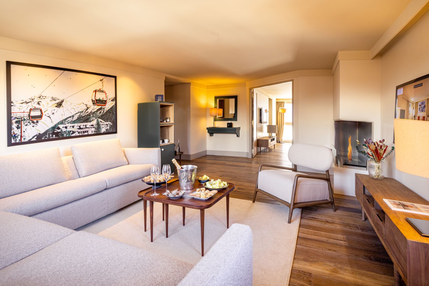Les Suites de la Potinière Courchevel - bright spacious living room with L shaped sofa chair fire and sideboard