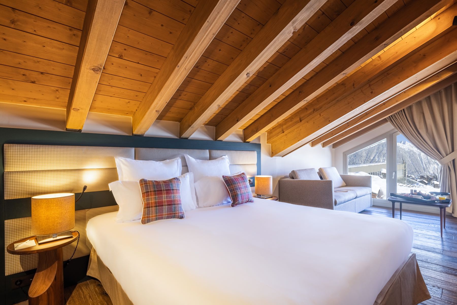 Les Suites de la Potinière Courchevel - Loft style bedroom with sofa area and large window with mountain views