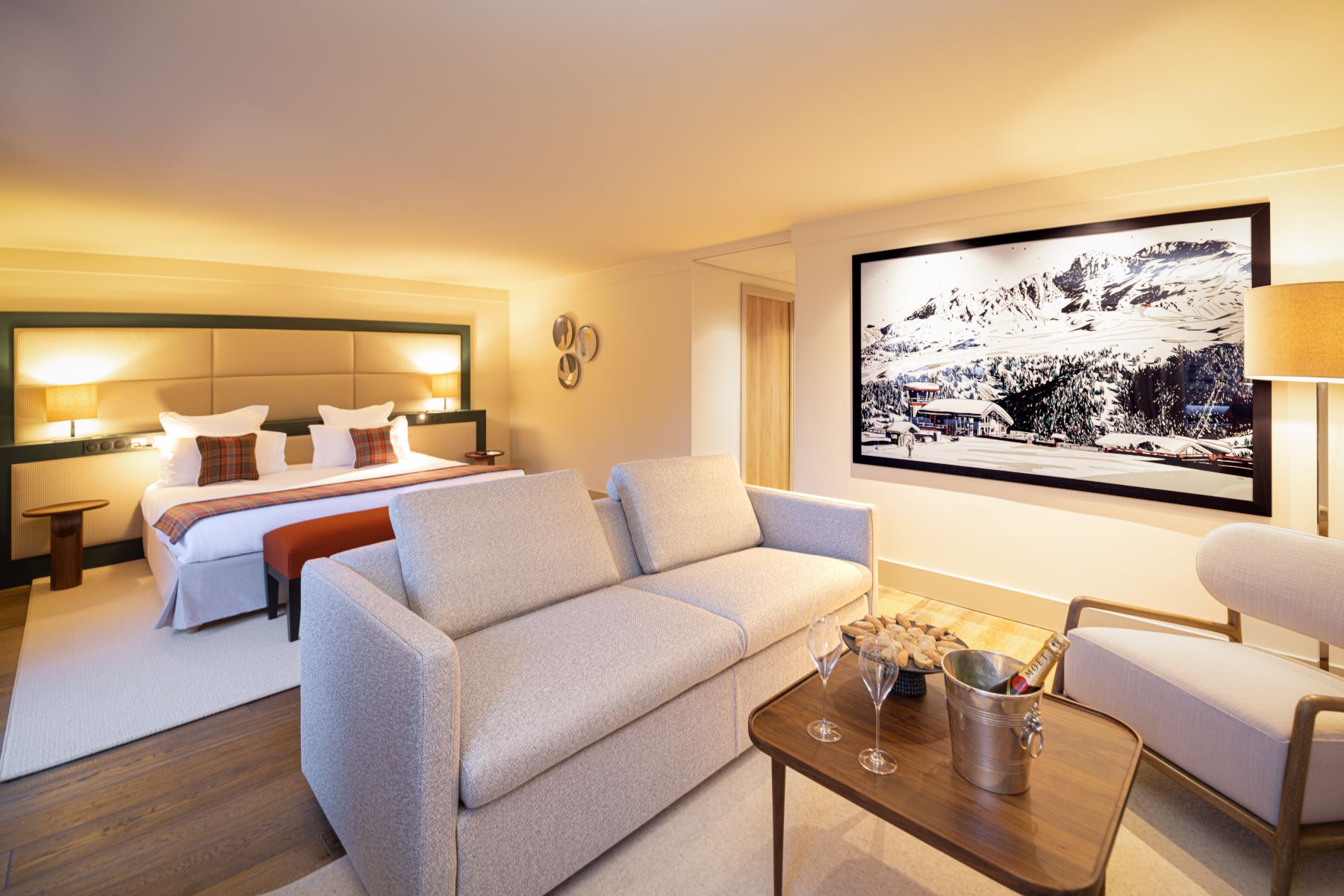 Les Suites de la Potinière Courchevel - Large light bedroom and living area with sofa chair and coffee table