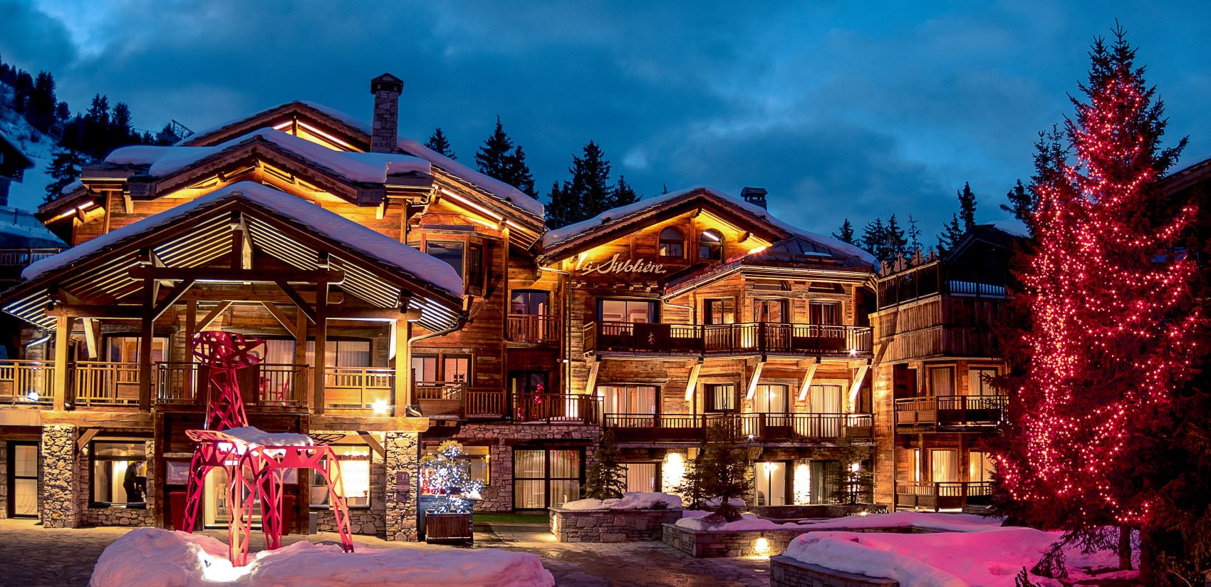 Hotel La Sivolière Courchevel - Exterior trees and sculpture it up at night