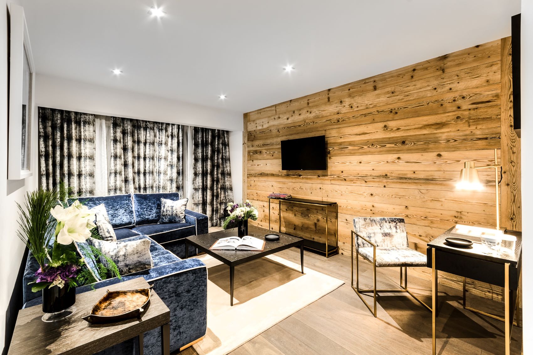 Hotel La Sivolière Courchevel - snug living room with corner sofa large windows coffee table desk and tv
