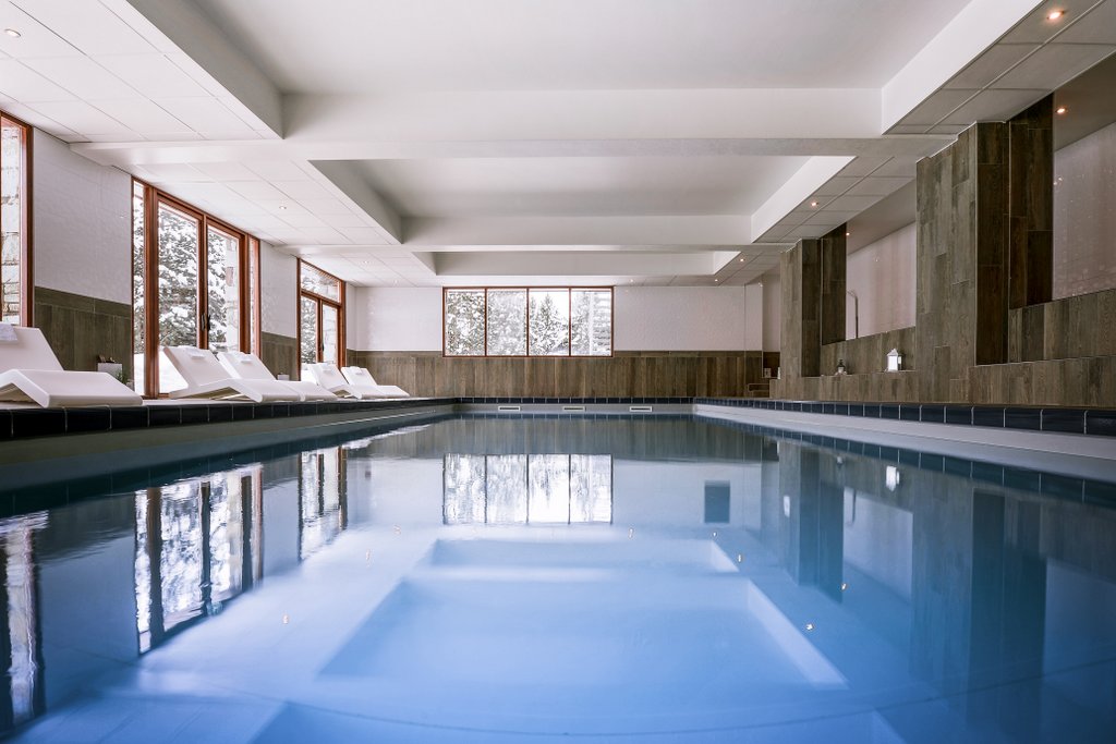 Hotel Le Pic Blanc Alpe d'Huez - Hotel close up of indoor pool with loungers and snowy trees