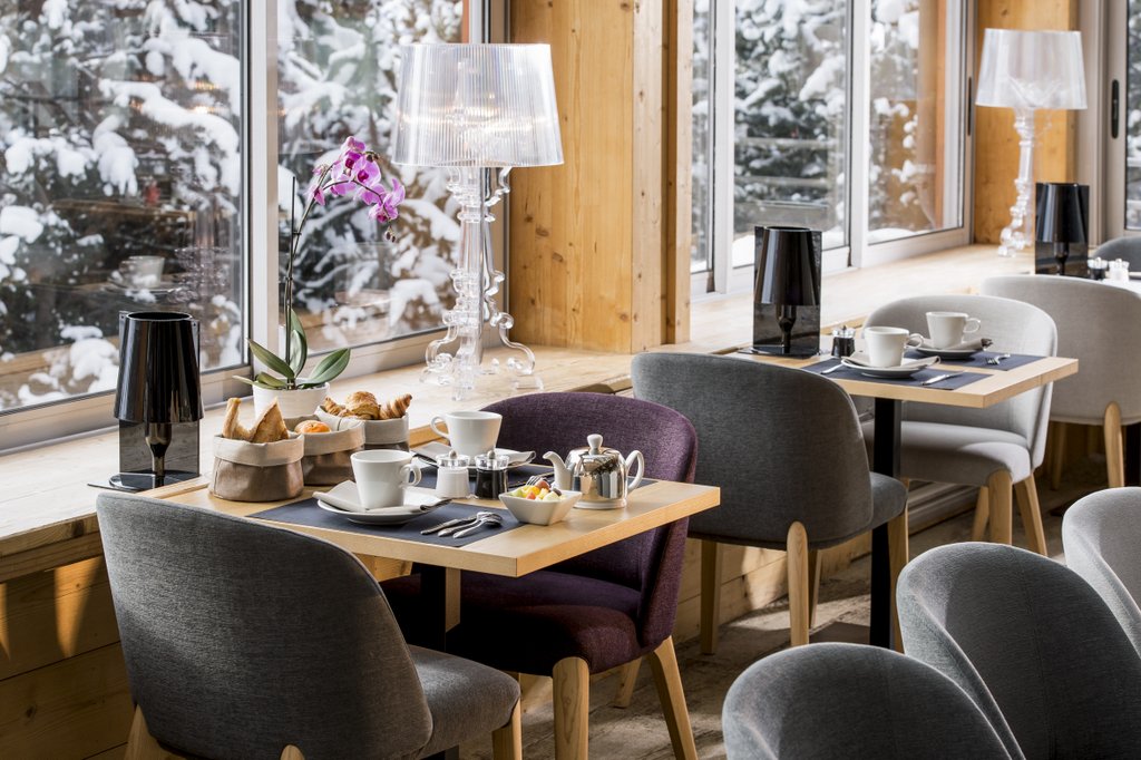 Hotel Le Pic Blanc Alpe d'Huez - Hotel breakfast room with continental breakfast and snowy forest views