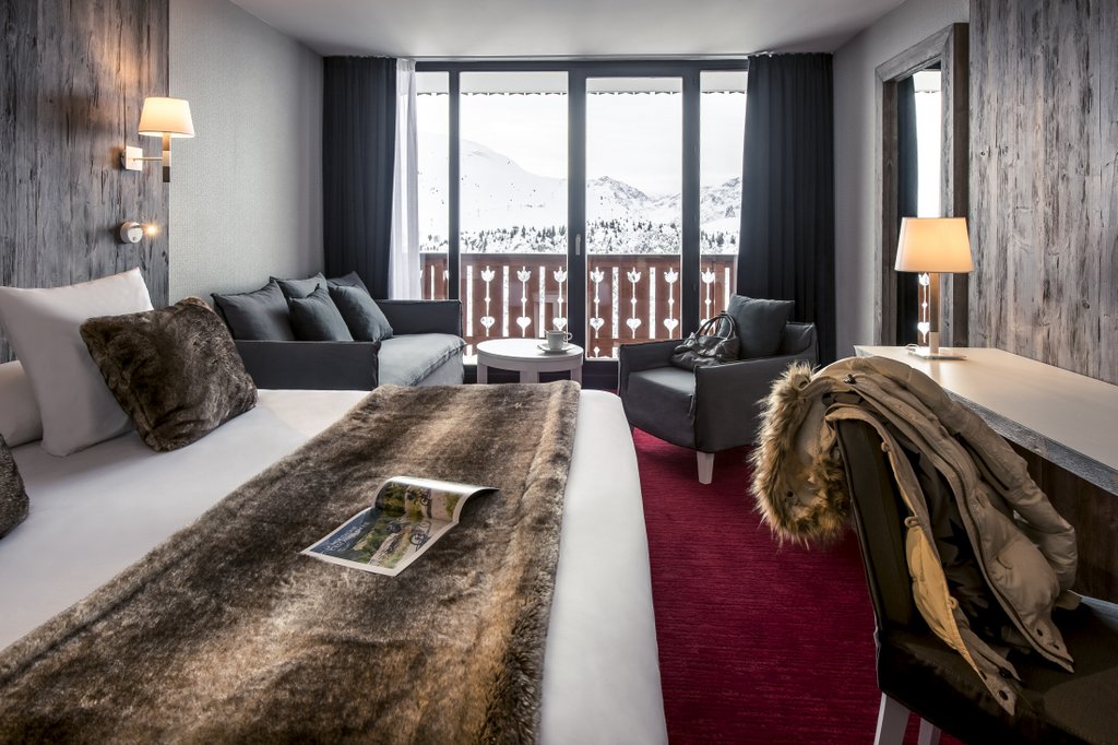 Hotel Le Pic Blanc Alpe d'Huez - Hotel bright contemporary bedroom seating area and balcony with mountain views