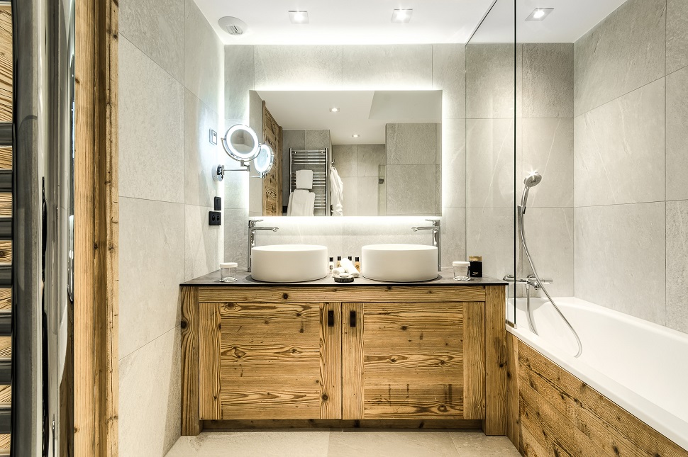 Hotel La Sivolière Courchevel - Spacious light bathroom with his and hers sinks bath with sower heated towel rail and vanity mirror