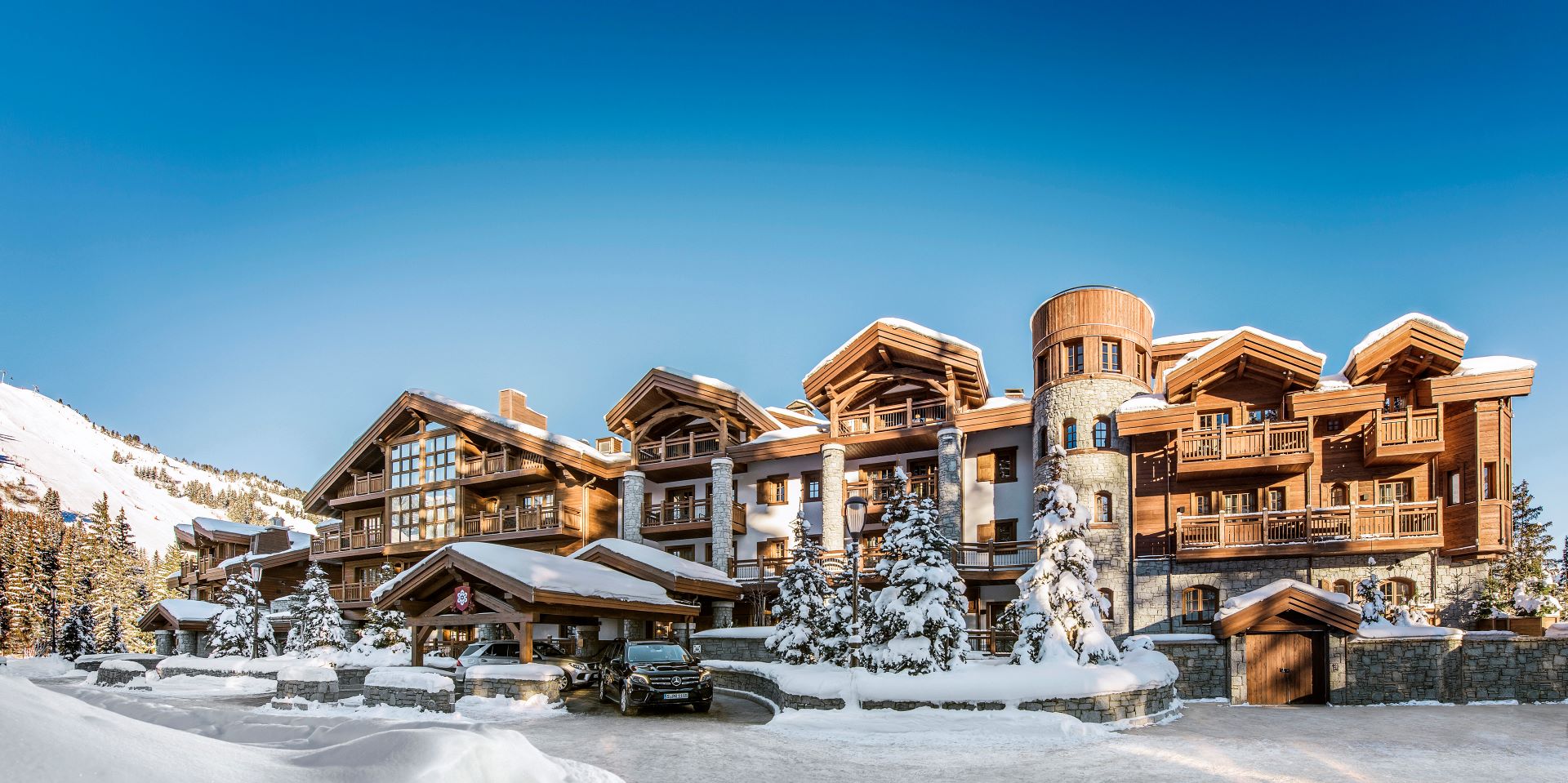 L'Apogée Courchevel Couchevel - hotel exterior during the day with snowy trees and mountains